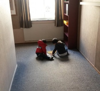 twee kinderen leggen een puzzel op de vloer